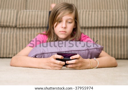 stock photo Teen or pre teen girl texting on her cell phone