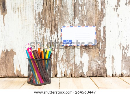 Color pencils and air mail on wooden background - Vintage effect style pictures