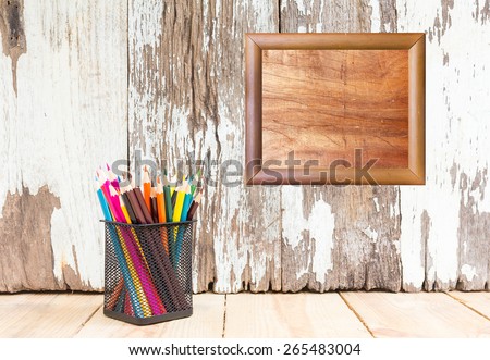 Color pencil and blank frame on wooden background - Vintage effect style pictures