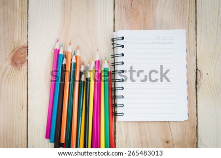 Note book and color pencils on wooden background - Vintage effect style pictures
