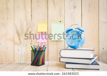Color pencils and book with clock on wooden background - Vintage effect style pictures
