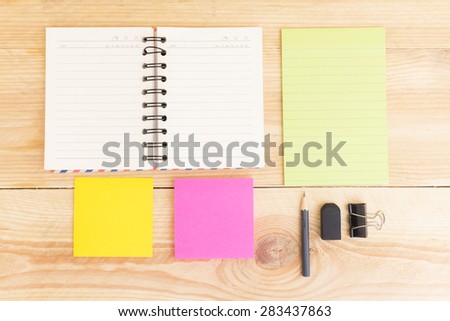 Notebook paper and school or office tools on wood table for background-vintage effect