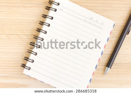 Blank open notebook with black pencil on wood table,Business template mock up for adding your text