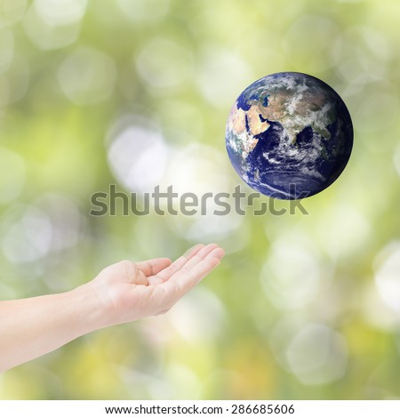 Human hands carrying global Earth. Environment concept. Elements of this image furnished by NASA.