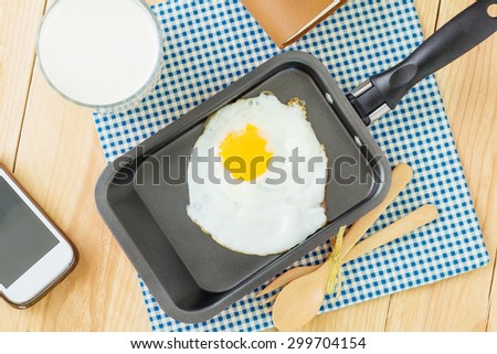 Fried egg on a pan and served with milk