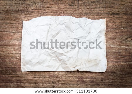 Close up view of torn piece of old paper for massage on wood background