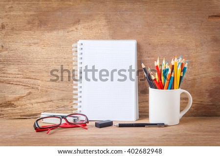 Open Notebook and school or office tools on wood table for background
