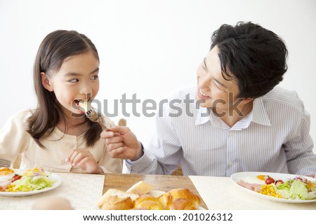 Father letting his daughter have breakfast