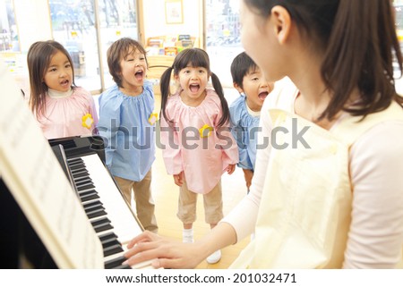 Kindergarten children singing along to the piano of kindergarten teachers
