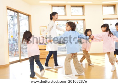 Kindergarteners and kindergarten teachers dancing in a circle