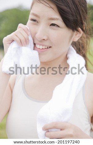 The woman wiping the sweat with a towel
