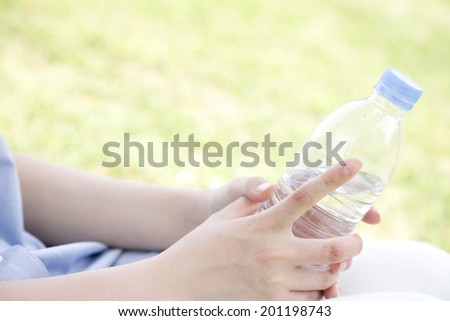The hand with a plastic bottle