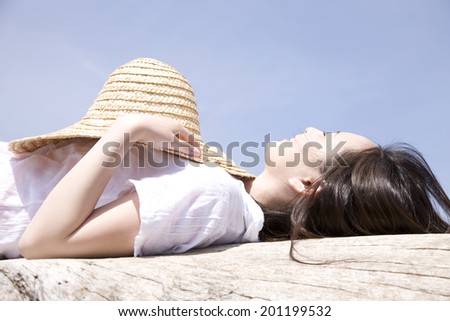 The woman taking a nap with a straw hat