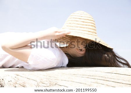 The woman taking a nap with a straw hat over her face