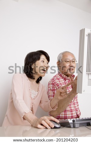 The elderly couple operating a personal computer