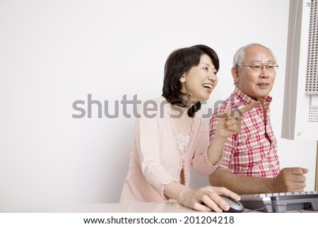 The elderly couple operating a personal computer