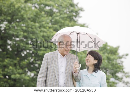 The elderly couple taking a walk with parasols