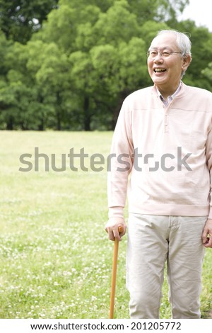 The old man walking in the park with a cane