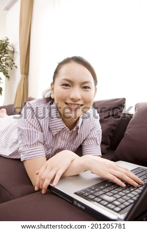 The woman operating the laptop on the sofa