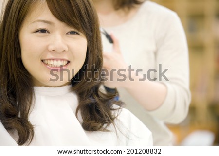 The woman receiving tongs service by a hairdresser