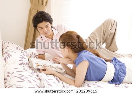 The man and woman reading magazines on the bed