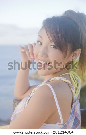 The woman smiles while turning back to the sea