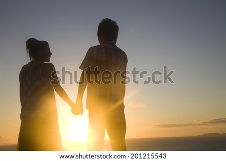 The silhouette of the couple holding hands in the evening