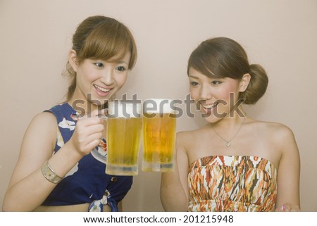 Two women making a toast with beers in get-together