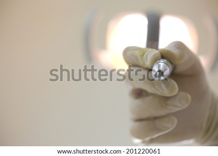 The hand of the dentist with a dental appliance