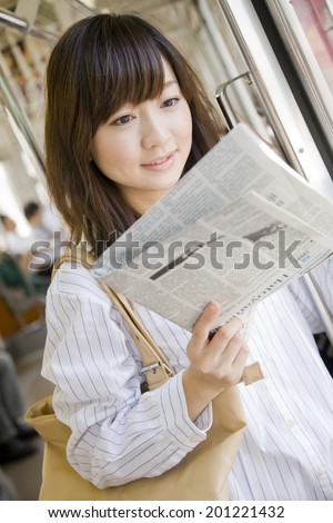 The woman reading a newspaper on the train