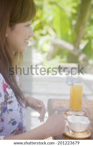 The woman chatting with friends in a cafe surrounded by fresh green