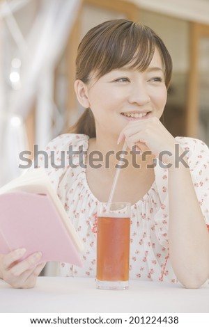 The woman reading a book in the open cafe