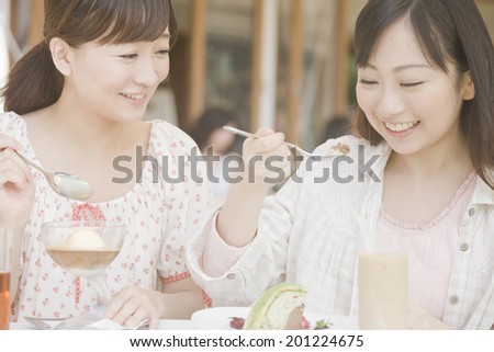 Two women eating dessert in cafe