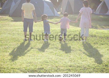 The rear view of the family walking the camping site