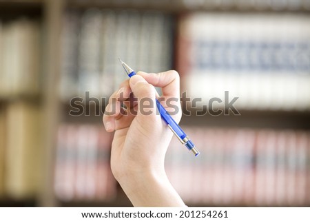 The hand of a middle school boy holding a mechanical pencil