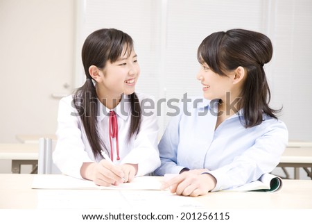 A middle school girl learning from a teacher at an institute