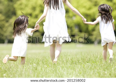 The sight of the back of an adult woman and 2 children running hand in hand