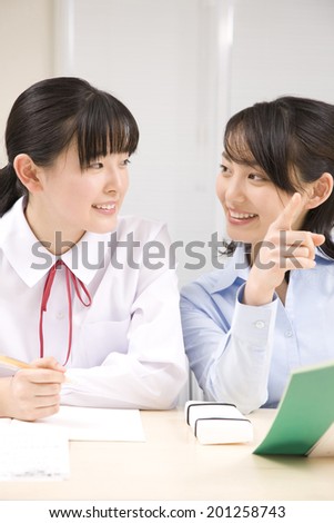 A middle school girl learning from a teacher at an institute