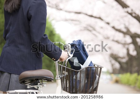A middle school girl walking a bike