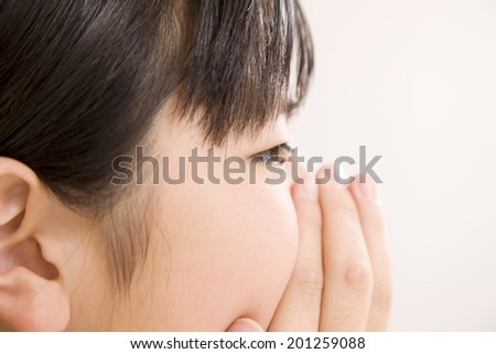 The profile of a girl covering her mouth with her hand