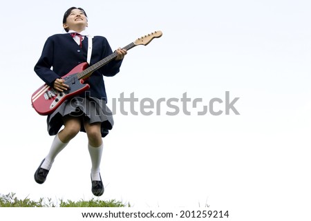 A middle school girl playing the guitar