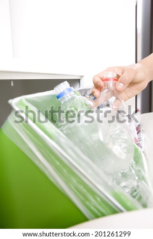 Hand of a woman throwing away a plastic bottle