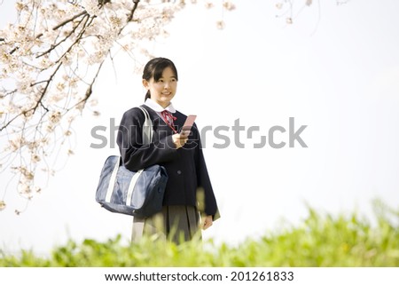 A middle school girl check her email with a mobile phone
