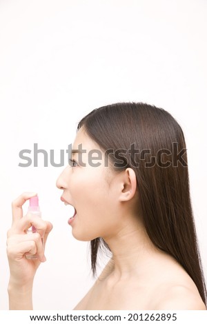 Woman using spray for bad breath
