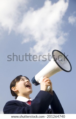A middle school girl making a loud sound through a megaphone