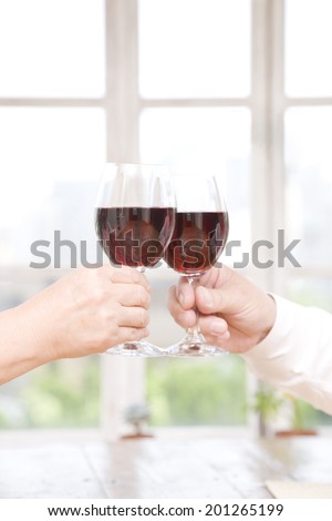 The hands toasting in red wine