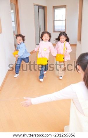 Kindergarten children running toward the kindergarten teachers