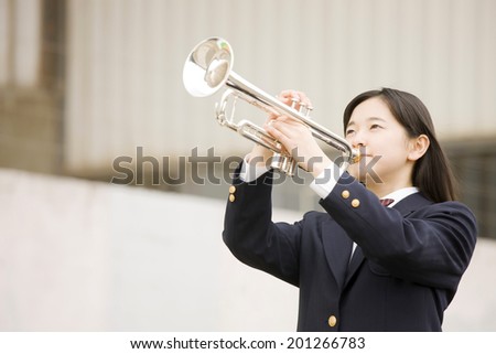 A middle school girl playing the trumpet