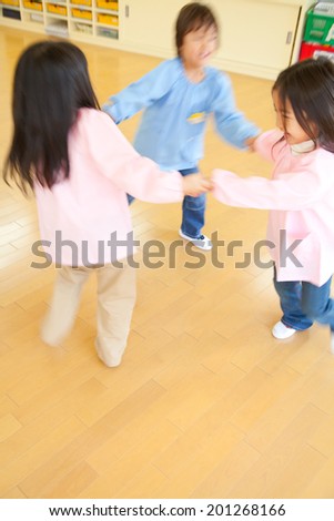 Kindergartener dancing in a circle