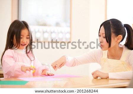 Kindergarten teachers and kindergarten girls folding origami